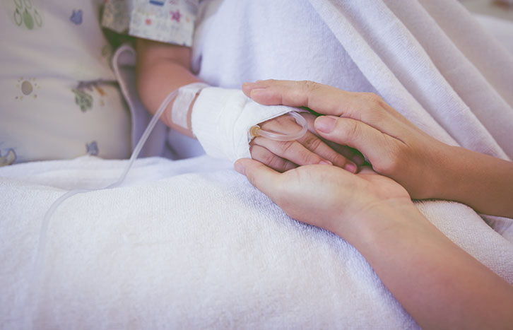 Hand hält die eines Kindes mit Infusion – einfühlsame Intensivpflege bei Aariana Pflegedienst